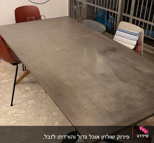 שולחן וכיסאות בחדר עם קירות חשופים